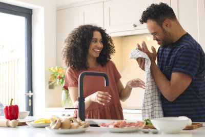 Man and Woman Washing Hands Before Preparing Meal In Kitchen