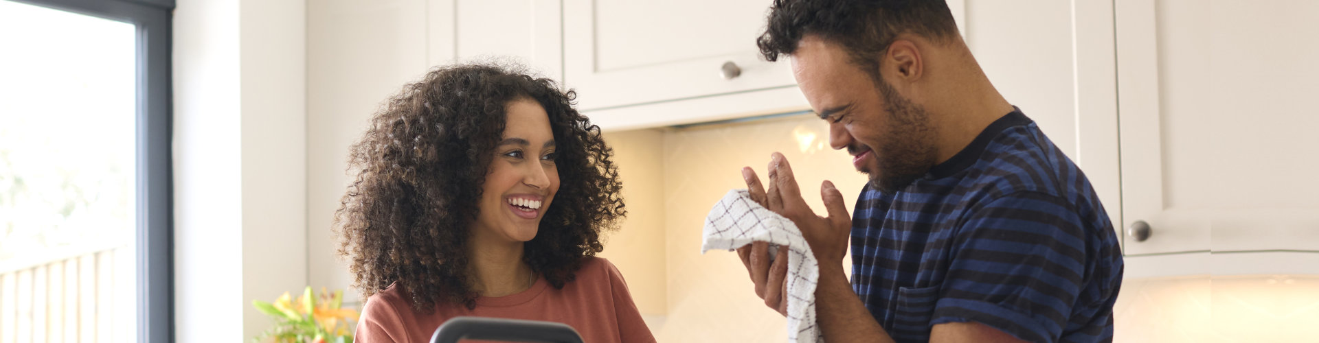 man And Woman Washing Hands Before Preparing Meal In Kitchen